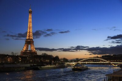 Paris By Night with Seine River Cruise and Roundtrip Luxury Transportation - The Eiffel Tower and Paris landmarks after dark